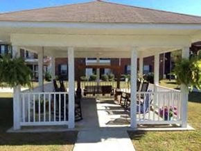 Tifton apartment for rent - a porch with a white railing and a pavilion with chairs