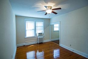 Washington apartment for rent - A room with a ceiling fan and a window with blinds.
