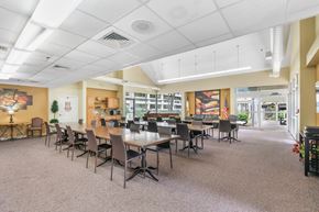 Jacksonville apartment for rent - large community room with tables, chairs, and piano