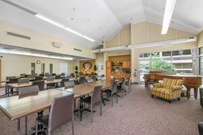 Jacksonville apartment for rent - community room with rows of tables and chairs and a piano at Sundale Manor Apartments