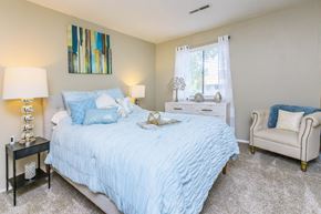 Roanoke apartment for rent - a bedroom with a bed and a chair and a window