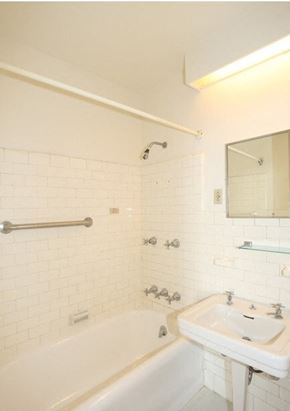 Ithaca apartment for rent - A white bathroom with a white tub, sink, and tiles.