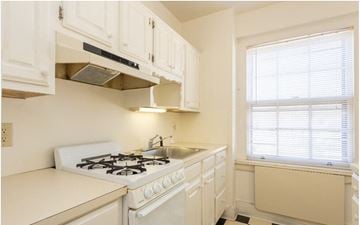Ithaca apartment for rent - A white kitchen with a stove and a window.