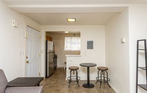 Ithaca apartment for rent - A kitchen area with a refrigerator, a table and a couch.