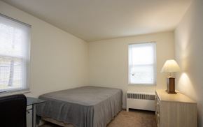 Ithaca apartment for rent - A bedroom with a bed, a chair, a nightstand, and a window.