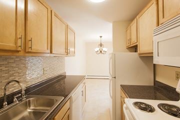 Millis apartment for rent - a kitchen with white appliances and black counter tops