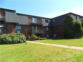 Millis apartment for rent - a large brick building with a lawn and sidewalk in front of it