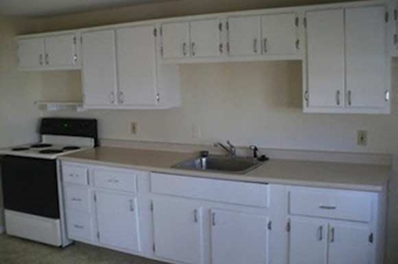 Milford apartment for rent - a kitchen with white cabinets and a sink and a stove