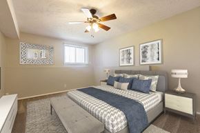 Omaha apartment for rent - a bedroom with a large bed and a ceiling fan