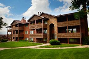 Omaha apartment for rent - an apartment building with a green lawn and a blue sky