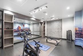 Portland apartment for rent - a gym with exercise machines and a wall mural of a city