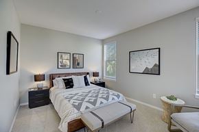 Sammamish townhouse for rent - a bedroom with a bed and a chair and a window