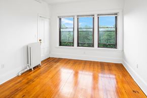 Cambridge apartment for rent - an empty room with wood floors and three windows