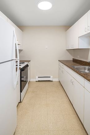 Cambridge apartment for rent - a kitchen with white cabinets and appliances and a tiled floor