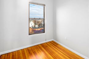 Cambridge apartment for rent - a bedroom with a large window and wooden floors