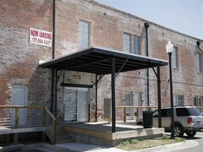 Suffolk apartment for rent - an old brick building with awning and a car parked outside