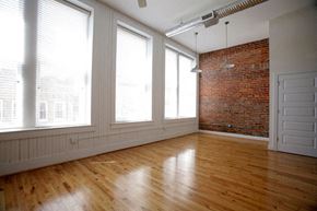 Suffolk apartment for rent - an empty living room with a brick wall and wood floors
