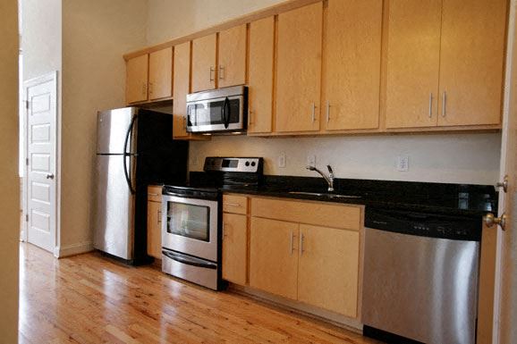 Suffolk apartment for rent - a kitchen with stainless steel appliances and wooden cabinets