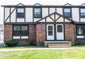 Amherst triplex for rent - the front of a brick house with a white and black facade