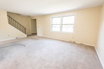 Amherst triplex for rent - the living room and dining room of a new home with carpet and a window