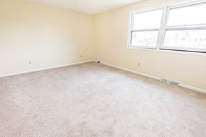 Amherst triplex for rent - a room with a carpeted floor and two windows