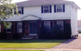 Williamsville triplex for rent - A white house with a black front door and steps.