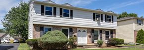 Williamsville triplex for rent - a white house with a blue sky in the background