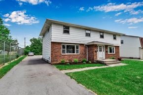 Williamsville triplex for rent - a white house with a white and red brick facade and a white car parked in the driveway