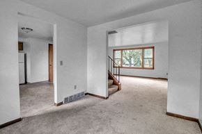 Williamsville triplex for rent - an empty living room with white walls and carpet