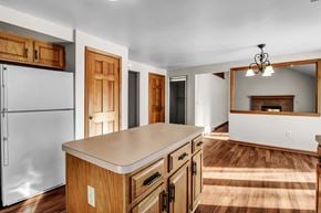 Depew house for rent - a kitchen with an island and a living room with a fireplace