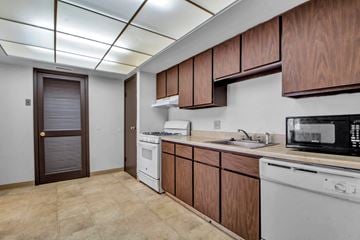 Amherst condo for rent - A kitchen with brown cabinets and white appliances.