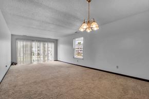 Amherst condo for rent - A room with a carpeted floor and a window with blinds.
