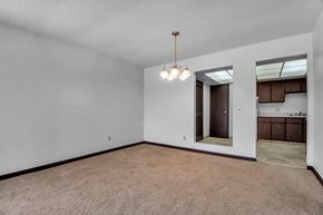 Amherst condo for rent - A room with a brown carpet and a chandelier hanging from the ceiling.