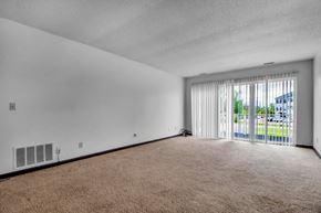 Amherst condo for rent - A room with a carpeted floor and a window with blinds.