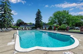 Amherst condo for rent - a swimming pool with trees and chairs around it
