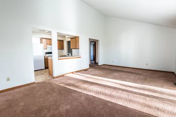 Amherst house for rent - a living room with carpet and a kitchen with a refrigerator