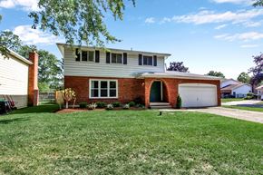 Tonawanda house for rent - a white house with a white garage door and a lawn