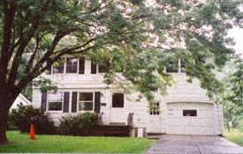 Williamsville house for rent - A white house with a black roof and a white fence.