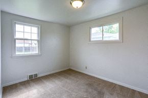 Tonawanda house for rent - A room with a carpeted floor and two windows.