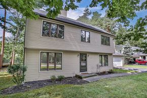 Amherst house for rent - the front of a house with a yard and trees