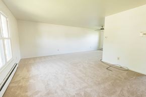 Amherst house for rent - A room with a carpeted floor and a window on the left side.
