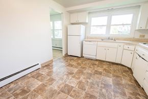 Amherst house for rent - A kitchen with brown tiled floors and white appliances.