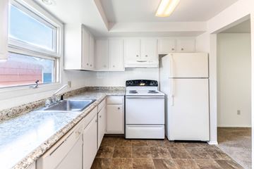 Amherst triplex for rent - A kitchen with white appliances and cabinets.