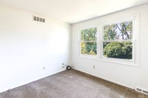 Amherst triplex for rent - A room with a window showing trees outside.