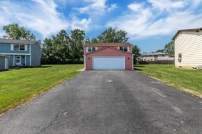 Amherst triplex for rent - A driveway leads to a red garage with a blue garage door.