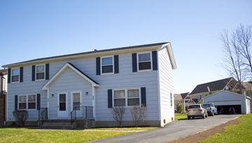 Amherst triplex for rent - a white house with a car parked in front of it