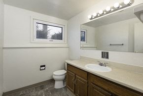Amherst house for rent - A bathroom with a toilet, sink, and mirror.