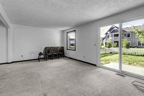 Amherst triplex for rent - A room with a grey carpet and a chair.