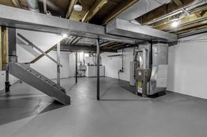 Amherst triplex for rent - A large, empty industrial space with a staircase and ductwork.