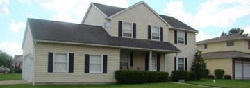 Amherst triplex for rent - A two-story house with a grey roof and white siding.